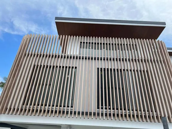 Upper storey screened by deep vertical woodgrain aluminium blades