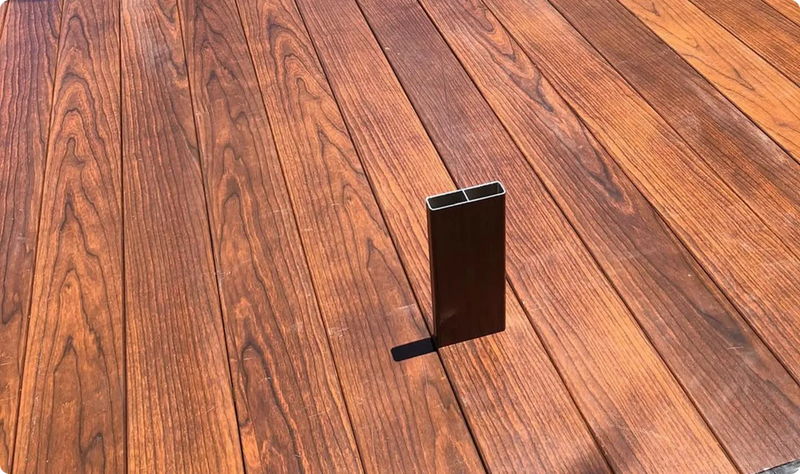 Woodgrain aluminium boards laid flat with a dark batten section standing on top